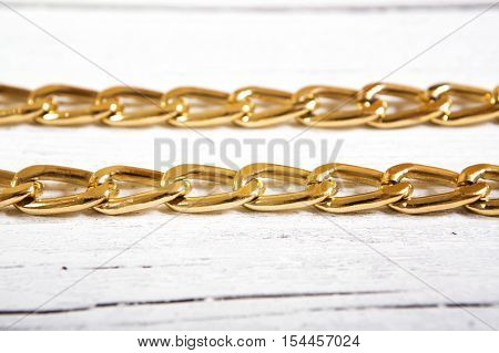 Brilliant gold baubles like christmas decoration. Yellow heart isolated on white wooden background.