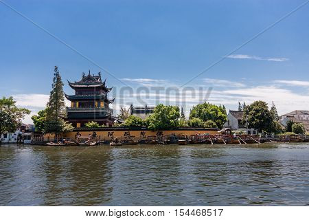 ZHUJIAJIAO CHINA - AUGUST 30 2016: Tourists see the sights of ancient water town with a history of more than 1700 years near Yuanjin Buddhist temple in Zhujiajiao China on August 30 2016.