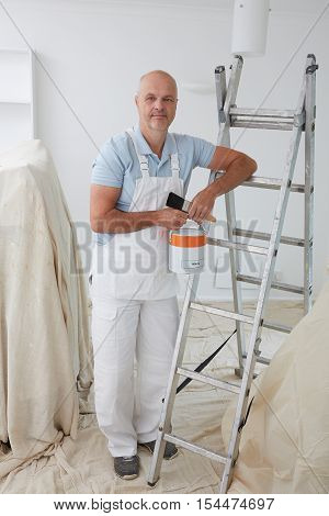 Portrait Of Decorator Painting Room In House