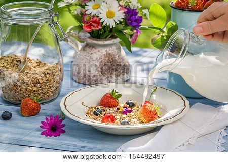Oatmeal with fruit and milk on old wooden table