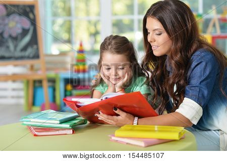 Portrait of a mother helping her daughter with homework