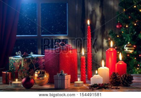 close up view of champagne with candles and gifts on color back