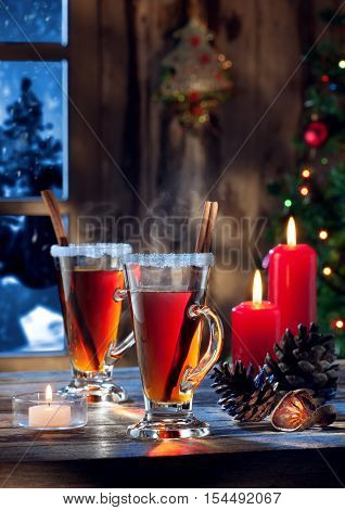 close up view  of glasses  with mulled wine with gift boxes on color back