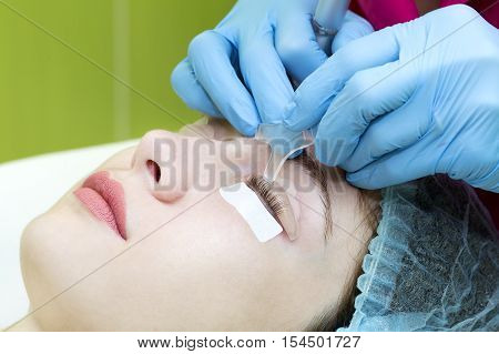 Woman on the procedure for eyelash extensions, eyelashes lamination