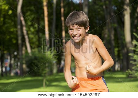 portrait of a boy in nature which shows his muscles