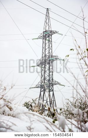 A high voltage power pylons, winter in snowy weather.