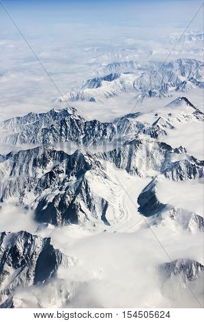 Mountains in snow and clouds. View from above. Winter nature.