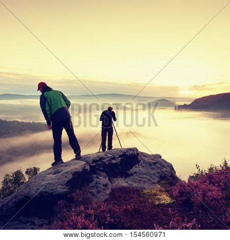 Hiker Look Down Into Fogy Valley. Photographer Stay On Cliff And Takes Photos.