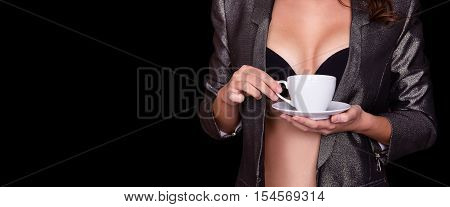 Sexy body of woman holding coffee cup. A coffee cup in the hands of a naked young woman. Isolated on black.