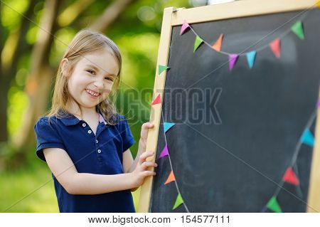 Very Excited Little Schoolgirl By A Chalkboard