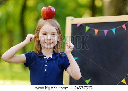 Very Excited Little Schoolgirl By A Chalkboard