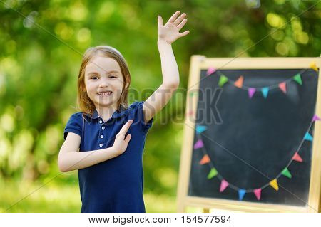 Very Excited Little Schoolgirl By A Chalkboard