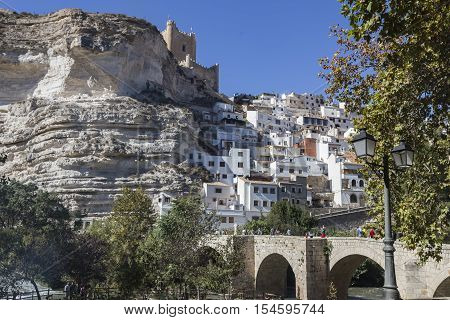 Alcala del Jucar Spain - October 29 2016: Roman bridge located in the central part of the town to its passage by the river Jucar at the top of mountain limestone is situated castle of Almohad origin of the century XII take in Alcala of the Jucar Albacete