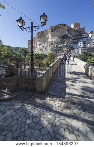 Alcala del Jucar Spain - October 29 2016: Roman bridge located in the central part of the town to its passage by the river Jucar at the top of mountain limestone is situated castle of Almohad origin of the century XII take in Alcala of the Jucar Albacete
