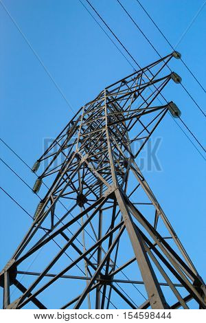 High voltage 110kV reliance power line tower side-bottom view on blue sky