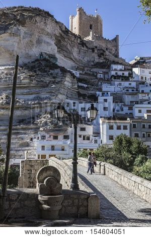 Alcala del Jucar Spain - October 29 2016: Roman bridge located in the central part of the town to its passage by the river Jucar at the top of mountain limestone is situated castle of Almohad origin of the century XII take in Alcala of the Jucar Albacete