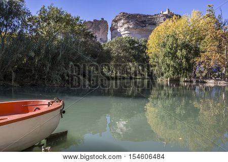 Alcala del Jucar Spain - October 29 2016: Jucar river boat of recreation in small lagoon in the central part of the town at the top of mountain limestone is situated castle of Almohad origin of the century XII take in Alcala of the Jucar Albacete province