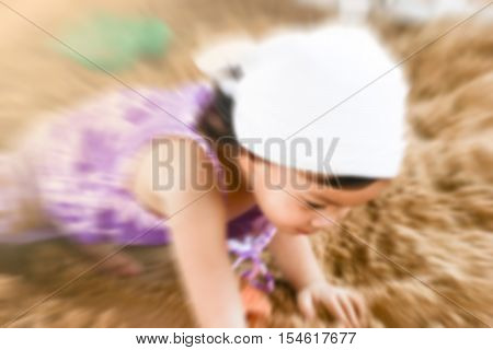 de-focused close up Asian little girl playing on sand