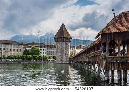Lucerne Switzerland - May 24 2016: View of Lucerne with famous wooden Chapel Bridge in Luzern Switzerland. Chapel bridge is located on Lucerne historical city center it's the famous and symbol of Switzerland main tourist attractions.