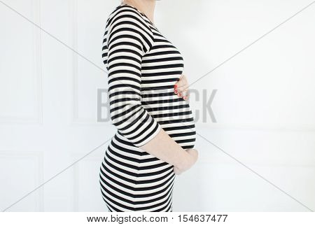 Anonymous pregnant woman in a french striped dress
