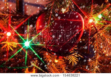 Christmas tree branch with Christmas toys on the background blurred and tinsel garlands