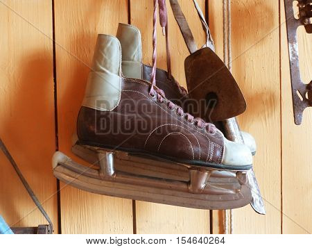 The brown old skates hanging on a wooden wall. Hockey.  Retro. Closeup.The dream of millions of boys of the last century
