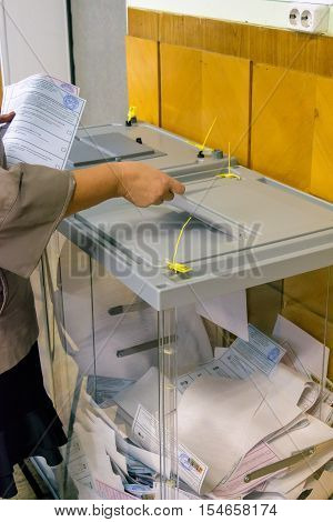 Orel, Russia - September 18, 2016: Woman puts the ballot in the ballot box at polling stations on the day of elections to the State Duma