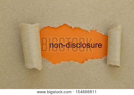 Non-Disclosure word written under torn paper .