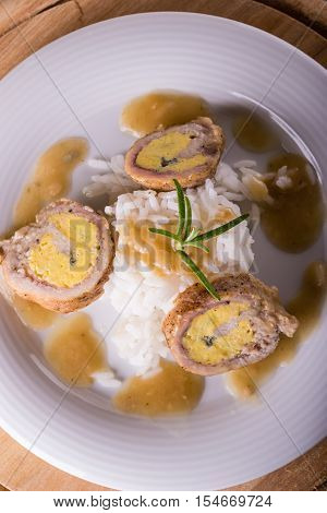 Top View On Meat Rolls With Egg And Cheese On White Plate