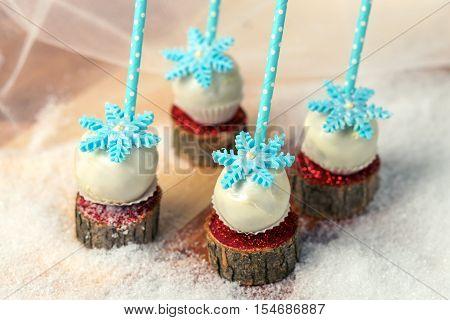 Lollypops side view on the snow. Decorated with sugar snowflakes. Close-up.