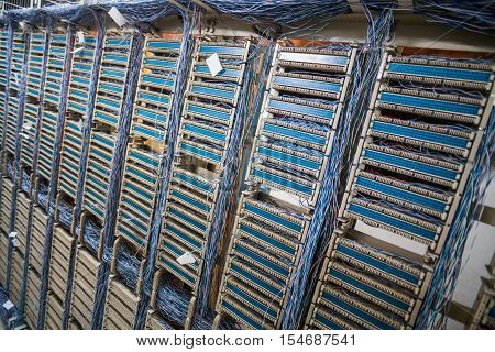 Color image of an old telephone exchange wit many wires.