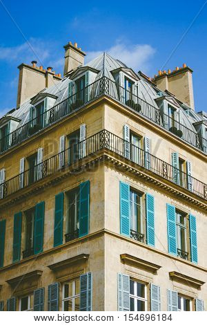 Symetrical exterior corner of Parisian apartments with blue sky.