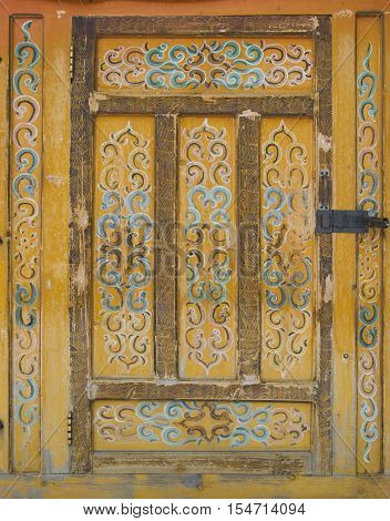 Old wooden door into the tent. The door is painted with a traditional pattern