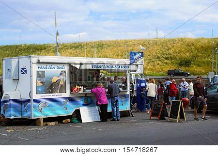 Tourists buying seals food in Eyemouth in Scotland. 07.08.2015