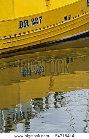 Yellow boat reflection in water. Eyemouth in Scotland UK. 07.08.2015