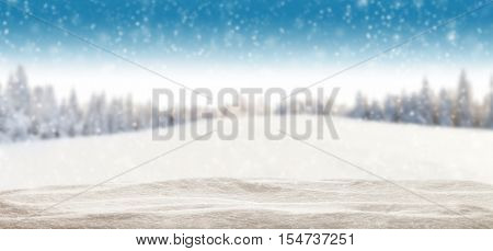 Pile of snow with blur winter panorama. Landscape with spruce trees, blue sky with sun light on background. Panoramatic view
