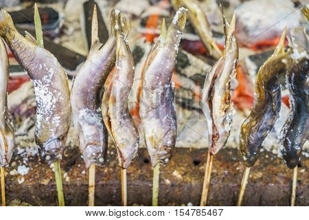 Fish with salt being grilled outdoors in Japan