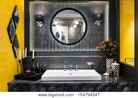 Interior of bathroom with washbasin faucet and black towel in hotel. Modern design of bathroom.