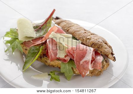 Close-up of tasty rye bread sandwiches with roast meat and vegetables, on a white background