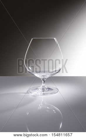 Still life with a empty cognac glass, on a grey background.