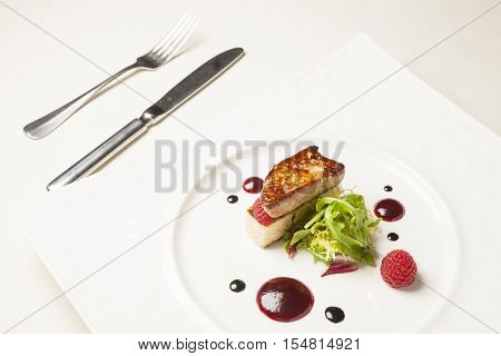 Foie gras in white plate on dining table