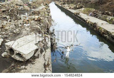 Garbage on the banks of the urban stream (the Lybid liver in Kyiv Ukraine).