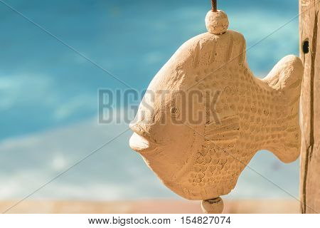 Ceramic fish scuplture against turquoise water at swimming pool