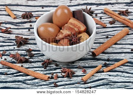 Thai Recipes : Stewed boiled egg with tofu and streaky pork ,call Khai Palo in Thai, take photo with herbs as Chinese star anise ,cinnamon,black pepper,cilantro roots and stems