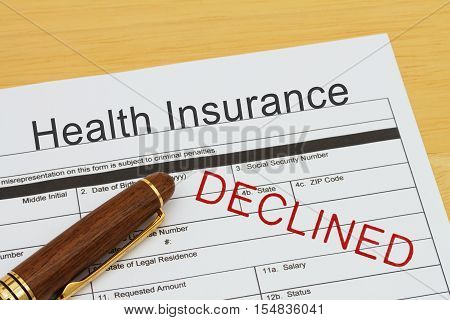 Applying for a Health Insurance Declined Health Insurance application form with a pen on a desk with an declined stamp