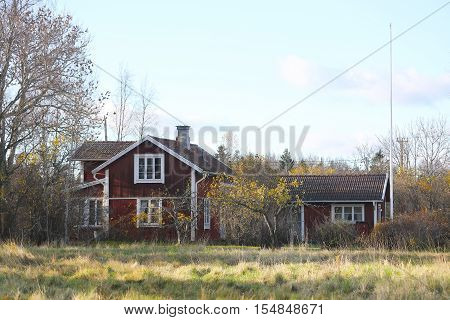 Red traditional cottages and white windows on a meadow