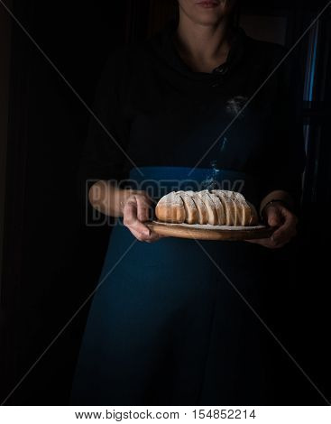 still life in the small Dutch-style. a woman holding a tray of bread.