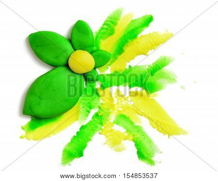 Yellow rose with green leaves made of plasticine on a white background. Flowers of modeling clay. Handmade art. Creative work.