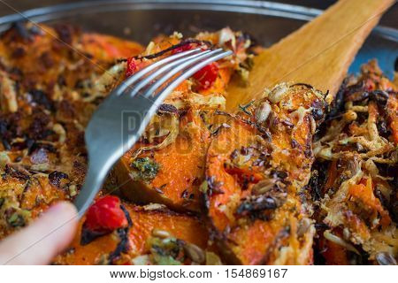Trying Vegetarian Baked Orange Pumkin, Vegetables, Herbs, Cheese With Folk