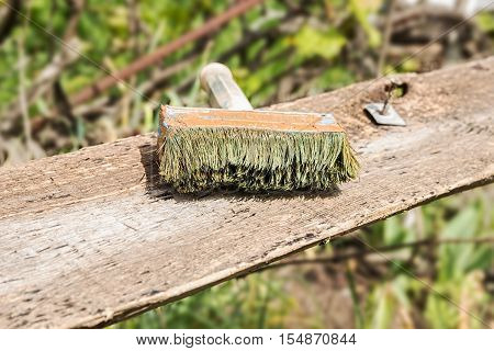 Old used paintbrush on a wooden board. Nature background.